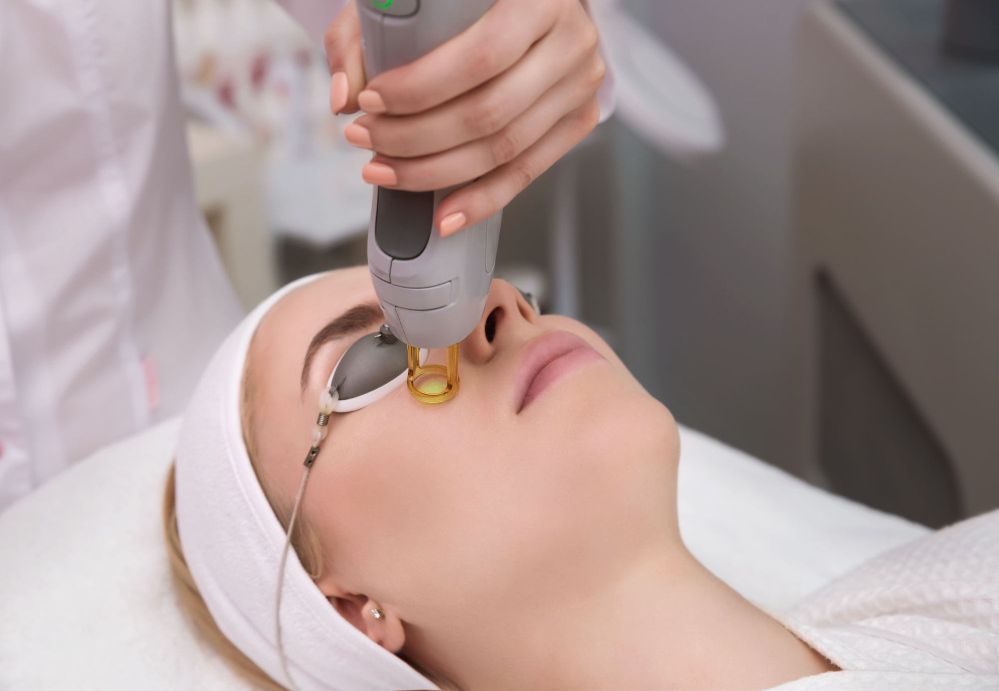 Therapist,Beautician,Makes,A,Laser,Treatment,To,Young,Woman's,Face